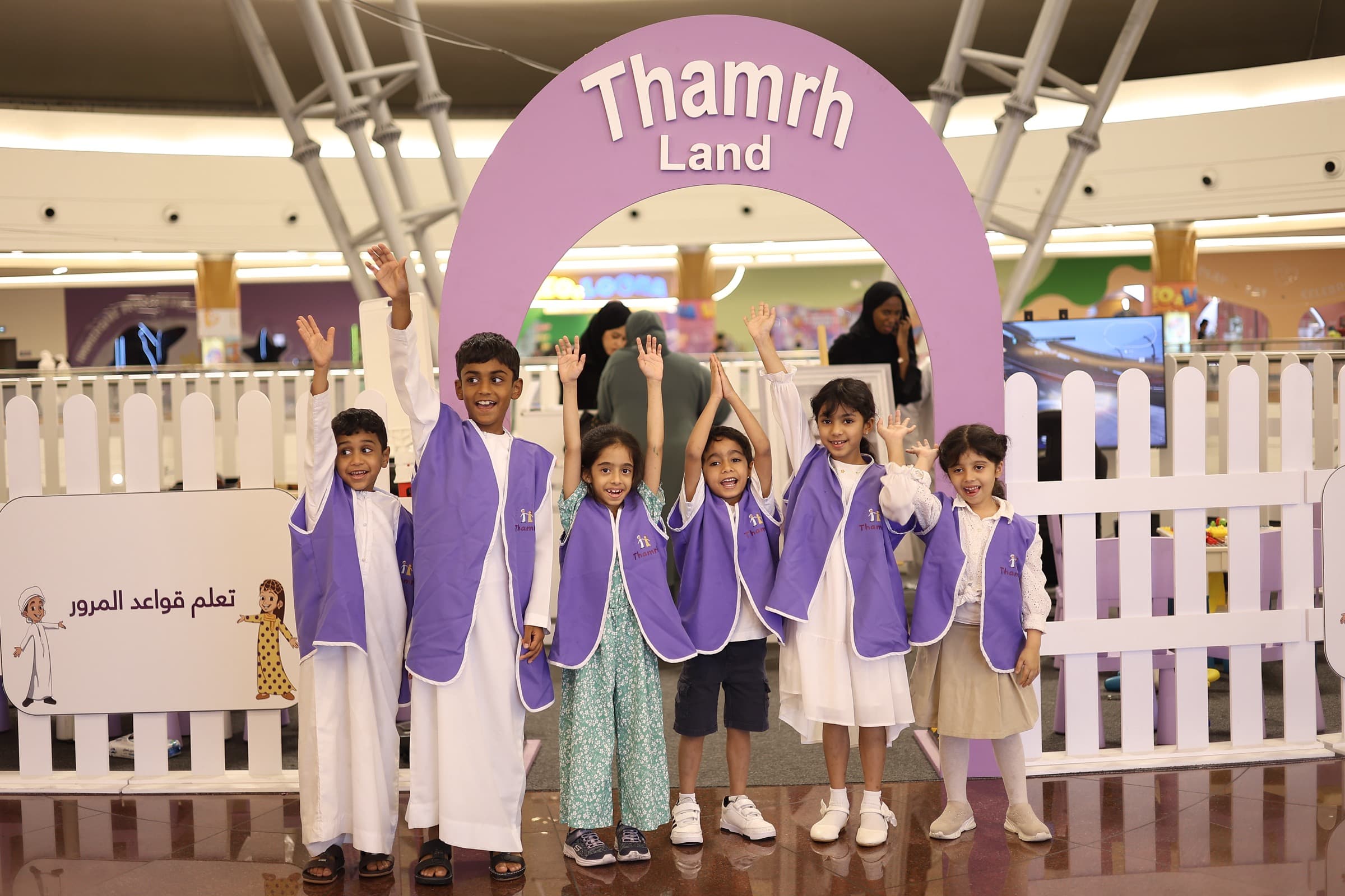 Children in Thamrh capes cheering at a family activation